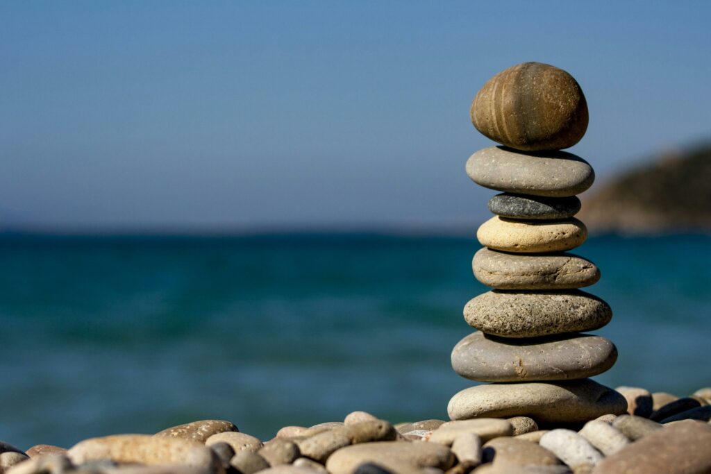 pexels-photo-235990-235990 A stack of balanced stones on a beach with a tranquil ocean backdrop for meditation and zen.